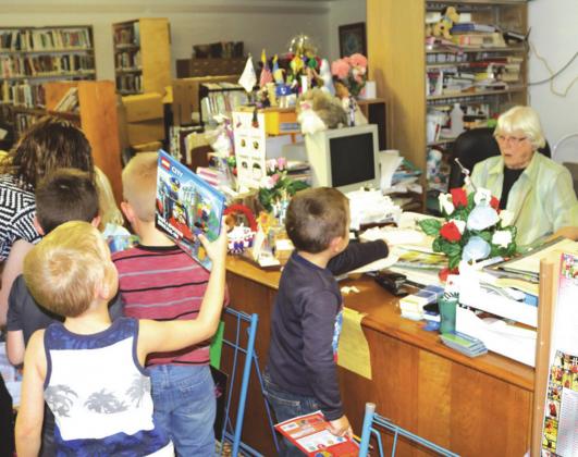 Presho City Librarian LaVerne Olson, seated at her desk, hosted many elementary students at her annual book fairs held at the library. LaVerne retired as librarian as of July 31, 2020.