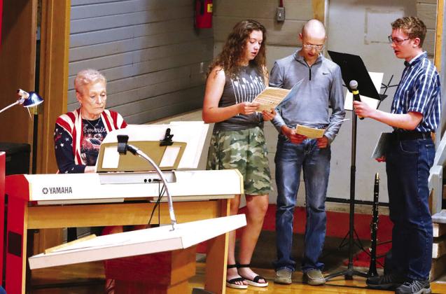 Ellen Valburg (pianist) provides accompaniment for Savannah Hendricks (left), Cyrus Hendricks (middle) and Daniel Jones (right) during their performance of Heroes at the Webster-Larson Memorial Day Services in Vivian.